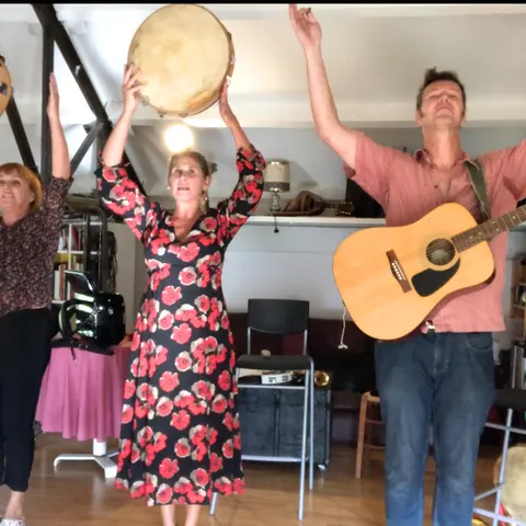 En répétition dans un salon, tambourins levés et guitare