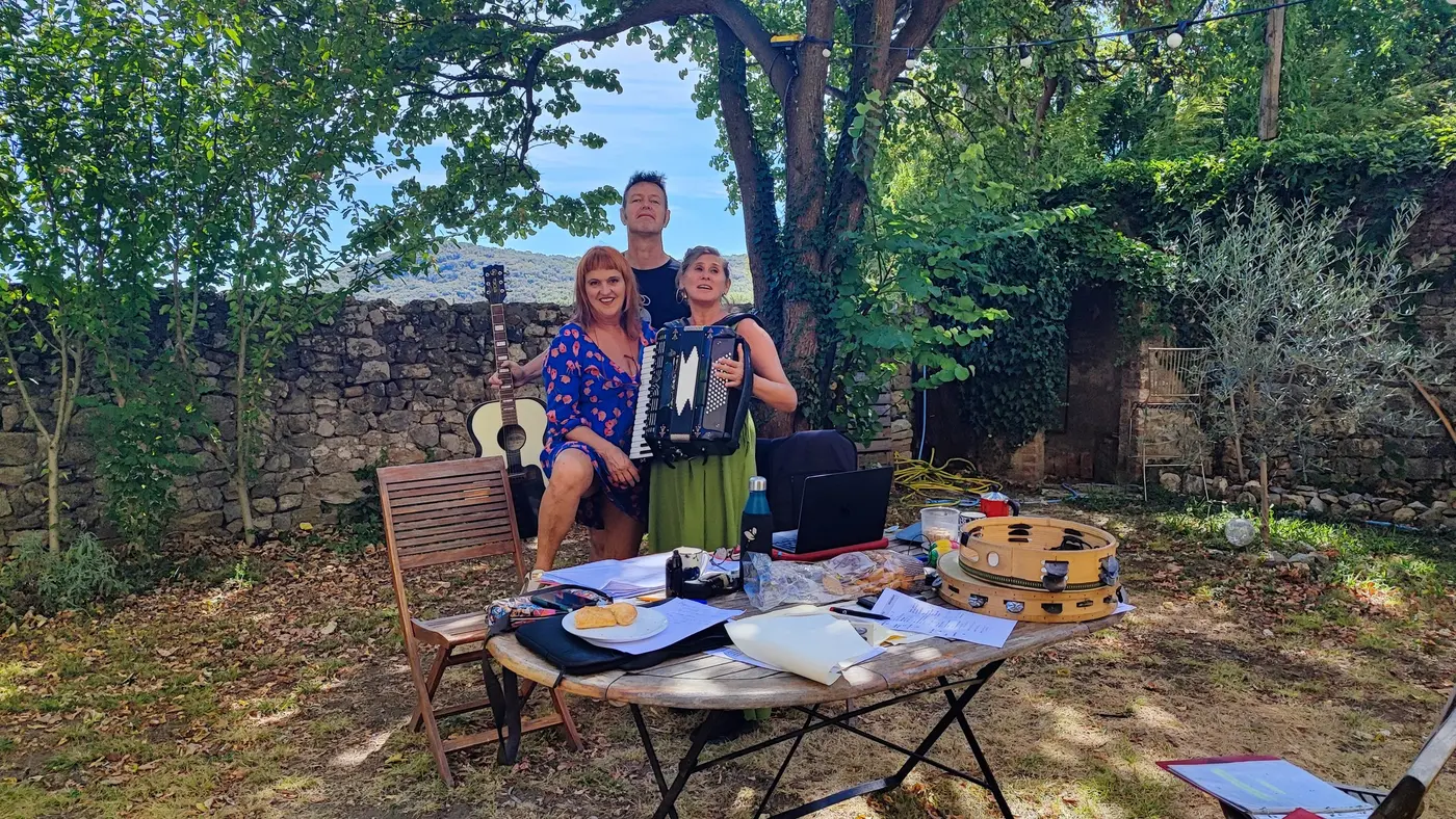 Le trio en plein air, accordéon et guitare, derrière une table