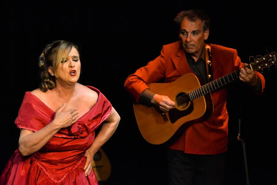 La chanteuse en robe rouge et le guitariste en veste rouge