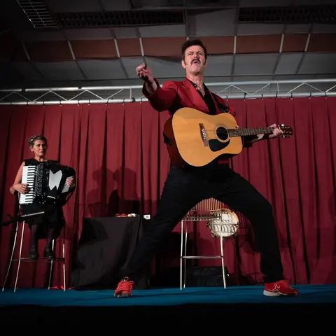 Alexandre Roux en pleine envolée à la guitare, l’accordéon derrière