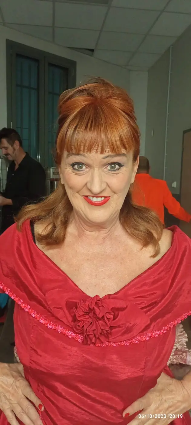 La chanteuse en robe rouge, tout sourire