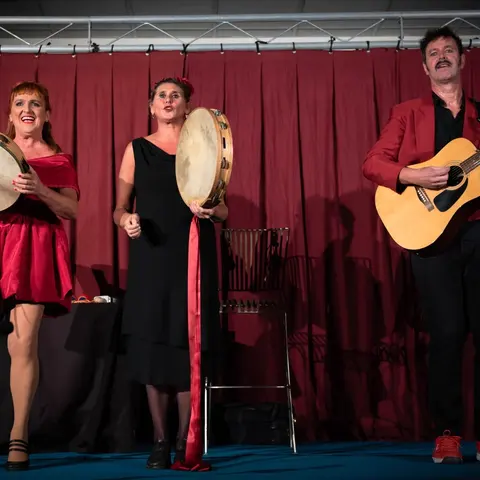 Deux tambourins et une guitare devant le rideau rouge
