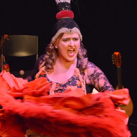 La diva coiffée de plumes fait voler sa jupe rouge