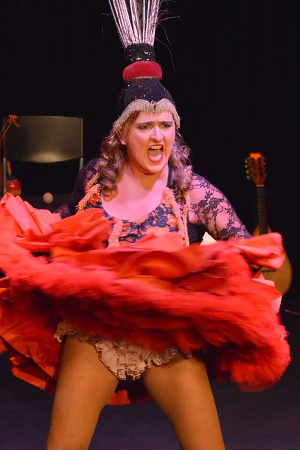 La diva coiffée de plumes fait voler sa jupe rouge